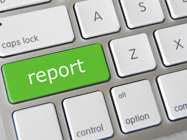 silver-colored computer keyboard with bright green button that says "report"